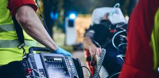 64 DEAD, 58 Injured After High Speed Train Collision Paramedic with defibrillator beside patient on stretcher