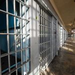 Row of empty prison cells with metal bars