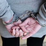 person in handcuffs with hands behind back