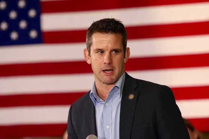 man speaking in front of a large American flag
