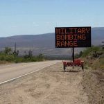 Trump Revives Forgotten Weapons Testing Program Portable electronic road sign on desert highway shoulder