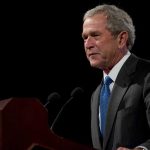 Bush Family Member Betrays Party – Turns Democrat George W. Bush speaking at a podium with microphones