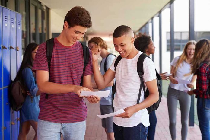shutterstock_735915358 Two students smiling and comparing papers in a school hallway