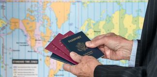 El-Sayed Admits He Carries Dual Citizenship! Hands holding multiple passports in front of a world map